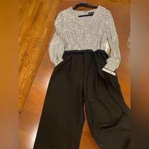 NWT black jumpsuit with pockets and tie belt. Silver sequin top